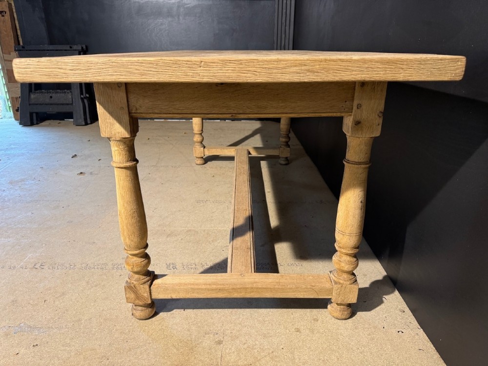 A light natural oak farmhouse dining table featuring turned legs, an H-stretcher base, and a planked top with cleated breadboard ends. View III