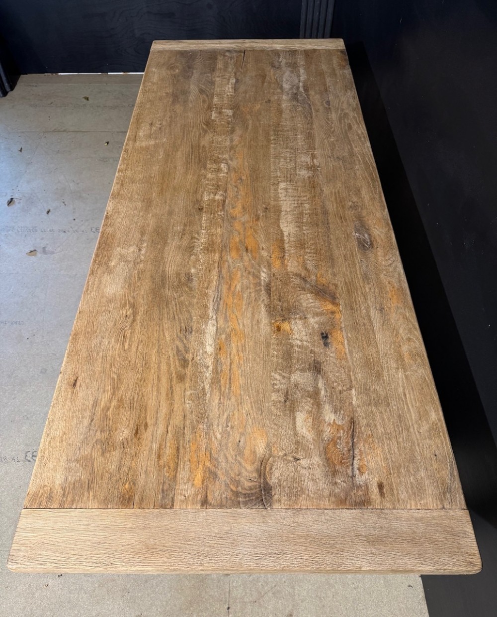 A light natural oak farmhouse dining table featuring turned legs, an H-stretcher base, and a planked top with cleated breadboard ends. View V