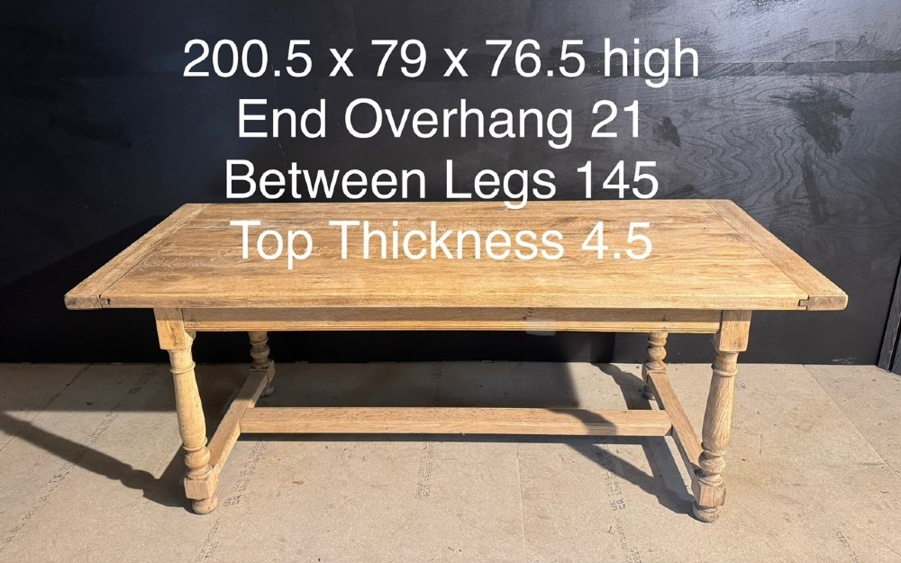 A light natural oak farmhouse dining table featuring turned legs, an H-stretcher base, and a planked top with cleated breadboard ends. View IX