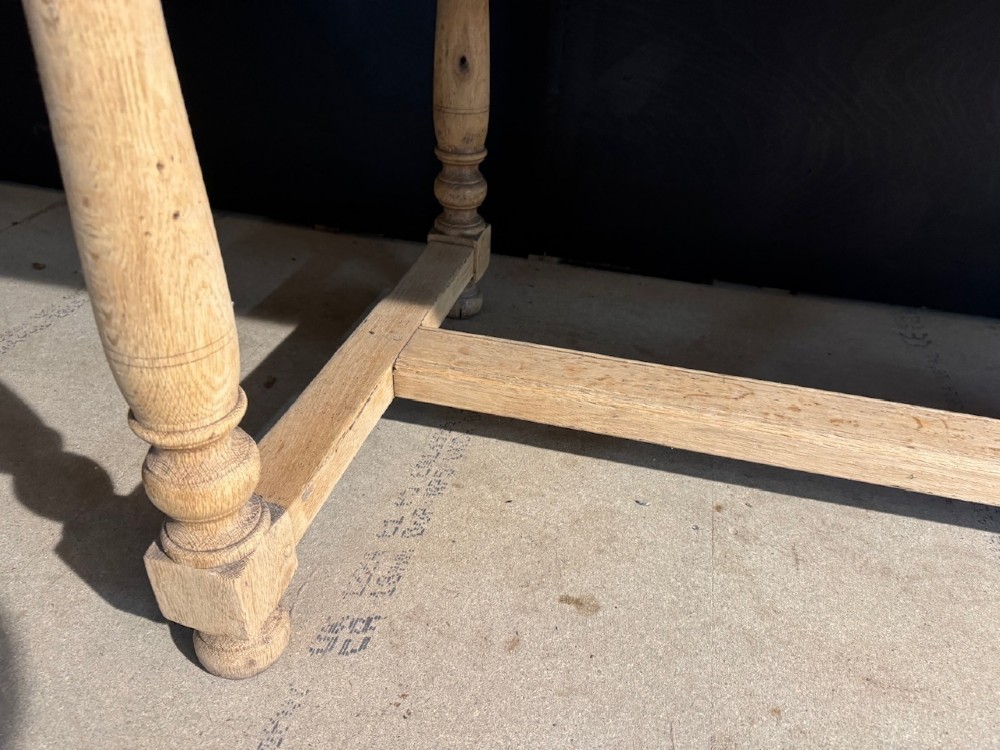A light natural oak farmhouse dining table featuring turned legs, an H-stretcher base, and a planked top with cleated breadboard ends. View XI