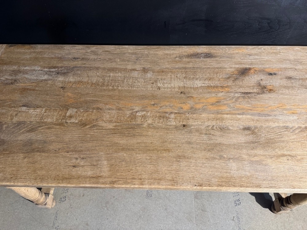 A light natural oak farmhouse dining table featuring turned legs, an H-stretcher base, and a planked top with cleated breadboard ends. View XIII