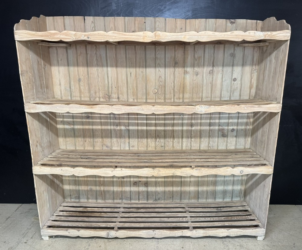 A large 19th-century French pine bakers rack featuring four slatted timber shelves and scalloped front aprons. View II