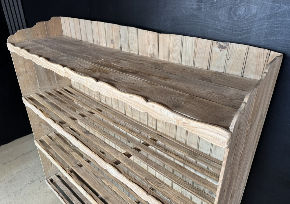 A large 19th-century French pine bakers rack featuring four slatted timber shelves and scalloped front aprons. View VI