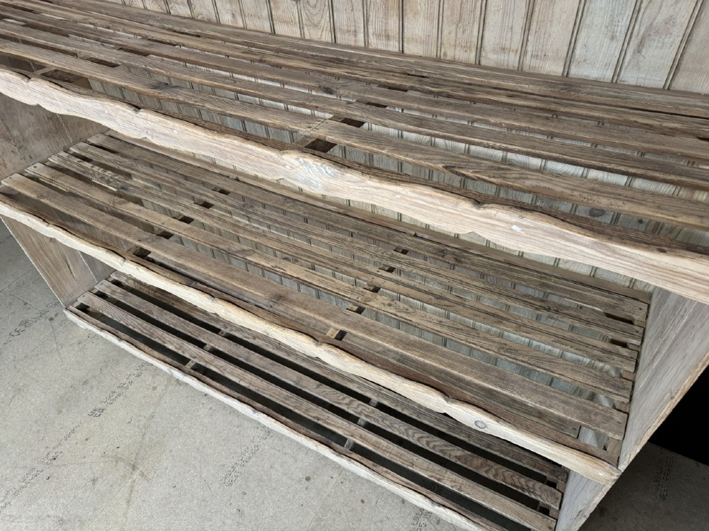 A large 19th-century French pine bakers rack featuring four slatted timber shelves and scalloped front aprons. View VII