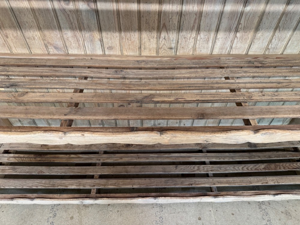 A large 19th-century French pine bakers rack featuring four slatted timber shelves and scalloped front aprons. View XII