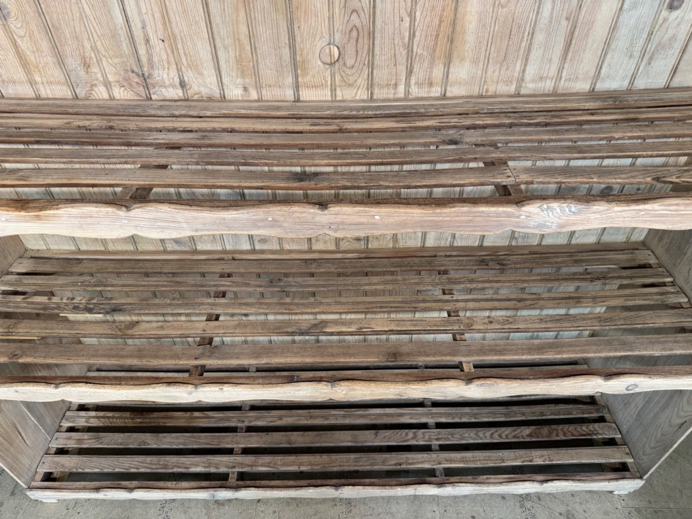 A large 19th-century French pine bakers rack featuring four slatted timber shelves and scalloped front aprons. View XIV
