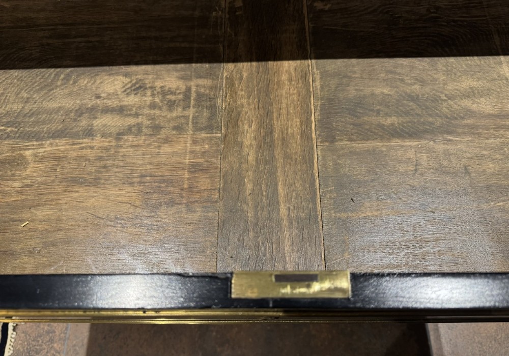 An ebonised Louis XVI style chest of drawers featuring three long drawers with brass rectangular mouldings, geometric handles, fluted tapered legs, and a white marble top. View IX