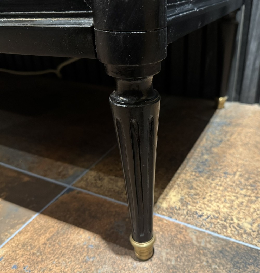 An ebonised Louis XVI style chest of drawers featuring three long drawers with brass rectangular mouldings, geometric handles, fluted tapered legs, and a white marble top. View XIII