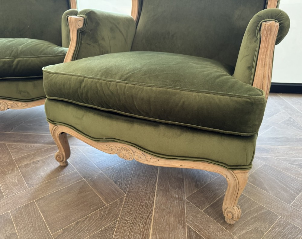 A pair of French wingback armchairs upholstered in olive green velvet with carved timber frames and cabriole legs. View III