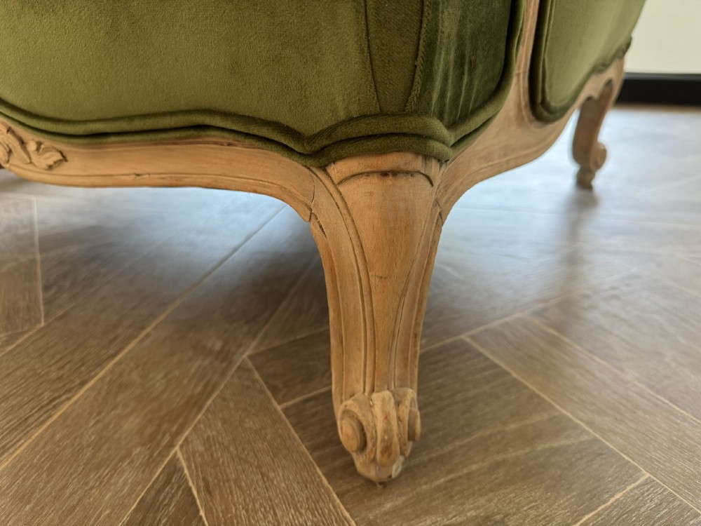 A pair of French wingback armchairs upholstered in olive green velvet with carved timber frames and cabriole legs. View V