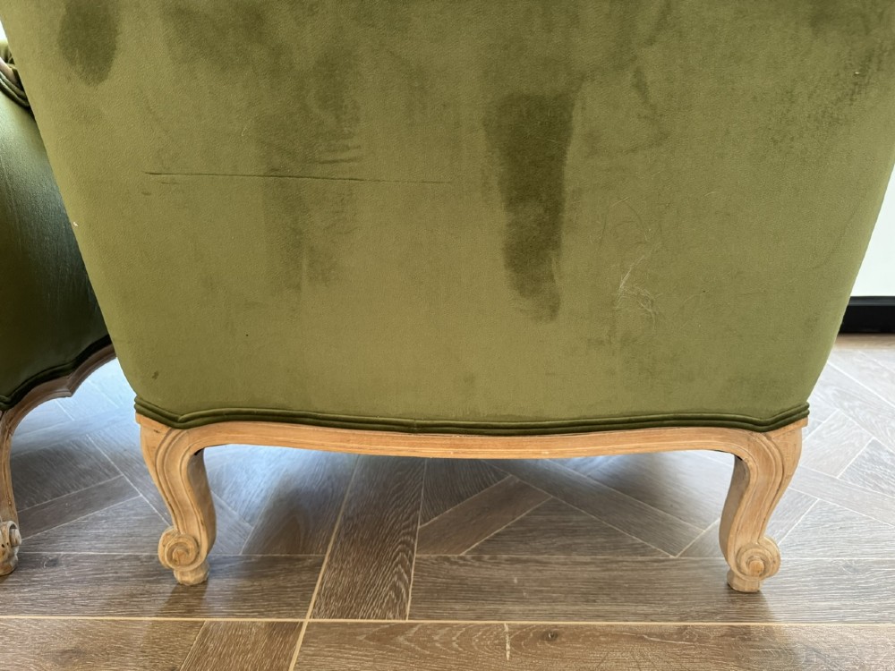A pair of French wingback armchairs upholstered in olive green velvet with carved timber frames and cabriole legs. View VIII