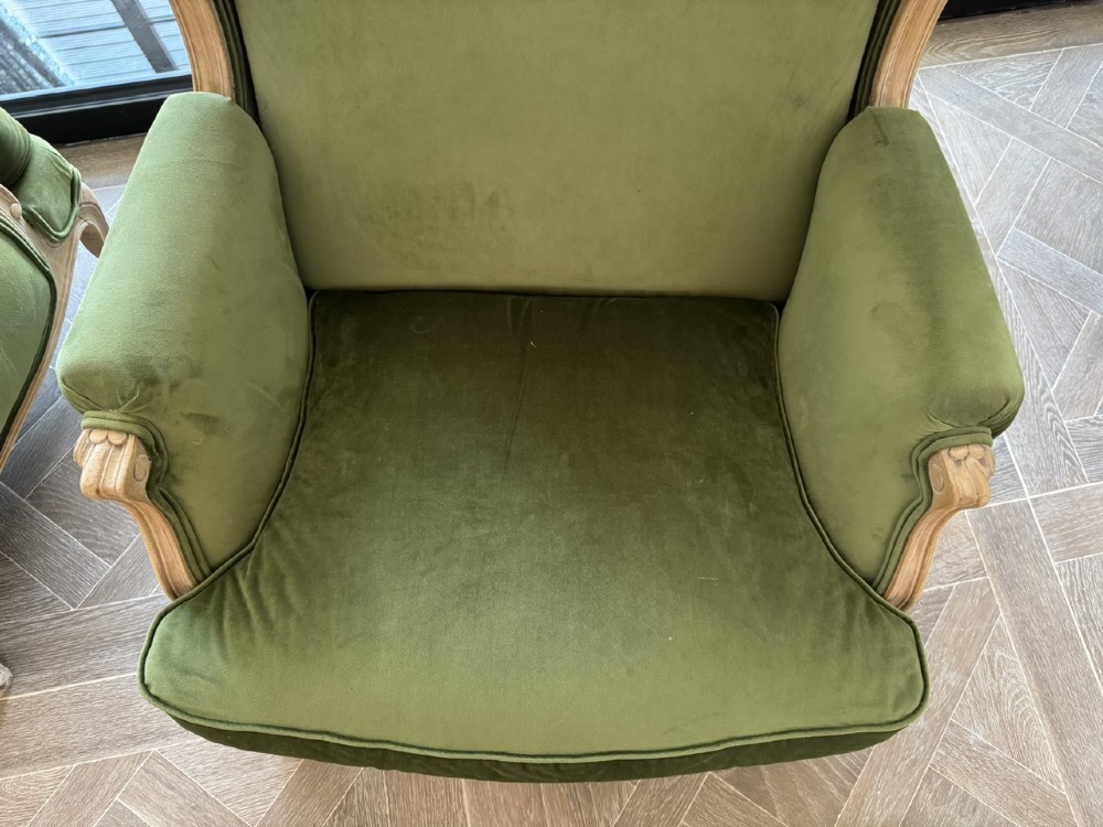 A pair of French wingback armchairs upholstered in olive green velvet with carved timber frames and cabriole legs. View IX