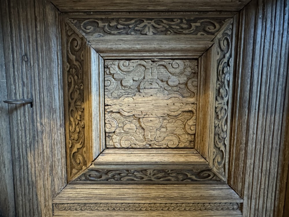 An 18th-century Flemish carved oak cabinet featuring detailed figurative columns, geometric door panels, lion head motifs, and bun feet. View VI