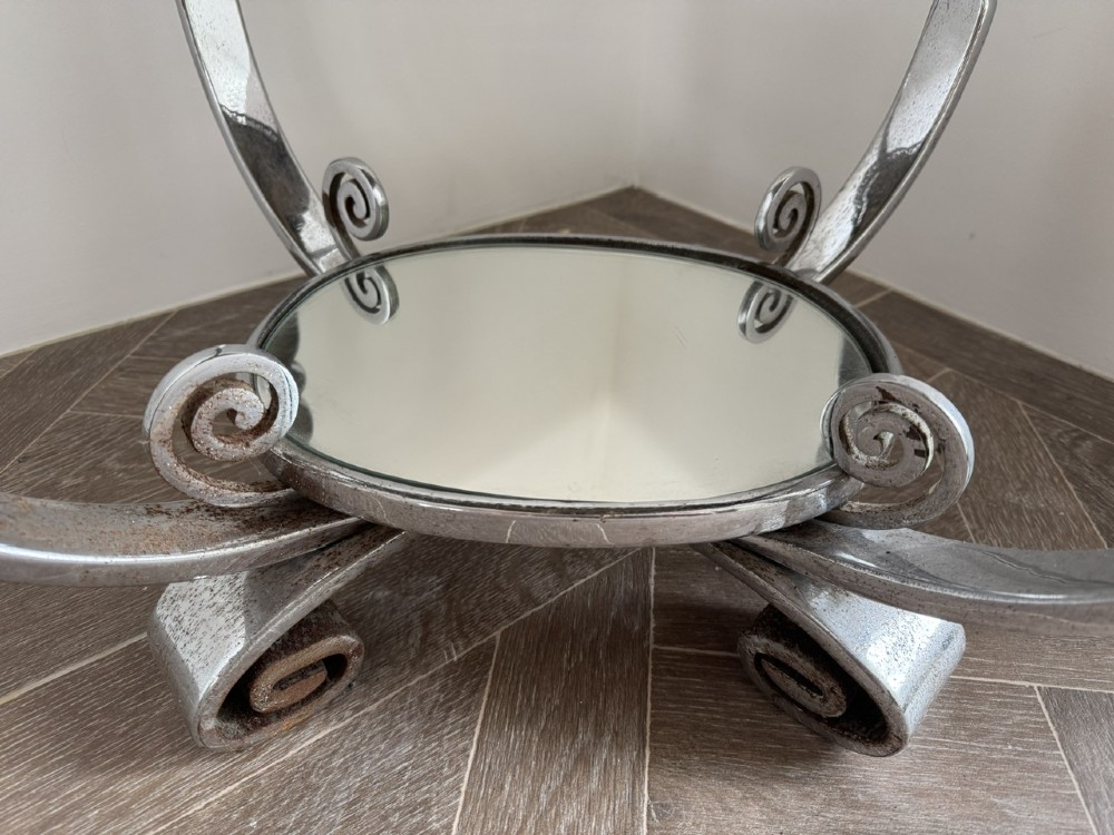 A circular chrome Art Deco side table featuring a mirrored glass top, Greek key frieze pattern, lower tier mirror, and scroll-footed legs. View III