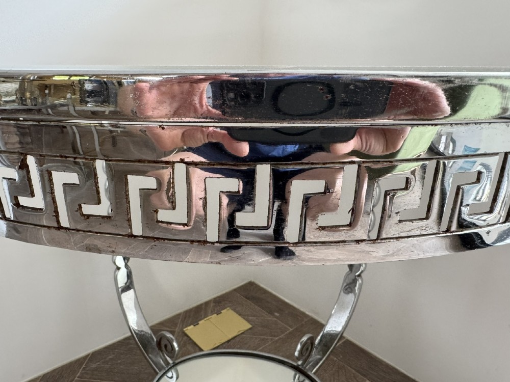 A circular chrome Art Deco side table featuring a mirrored glass top, Greek key frieze pattern, lower tier mirror, and scroll-footed legs. View IV