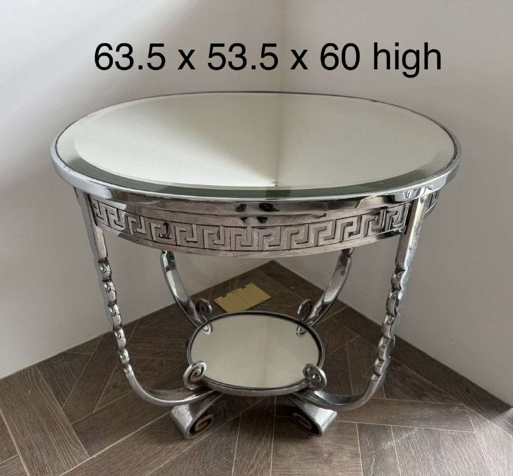 A circular chrome Art Deco side table featuring a mirrored glass top, Greek key frieze pattern, lower tier mirror, and scroll-footed legs. View XI