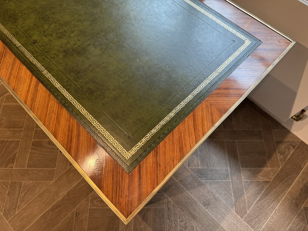 A French Louis XVI style writing desk featuring a green leather insert, wood parquetry veneer, three frieze drawers, and gilt bronze mounts. View VIII
