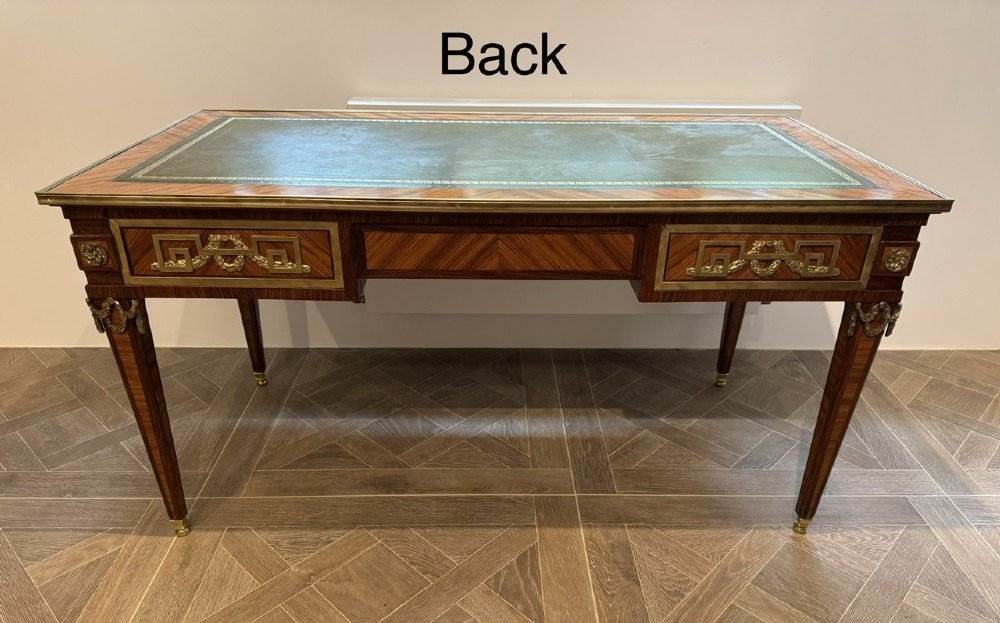 A French Louis XVI style writing desk featuring a green leather insert, wood parquetry veneer, three frieze drawers, and gilt bronze mounts. View XI