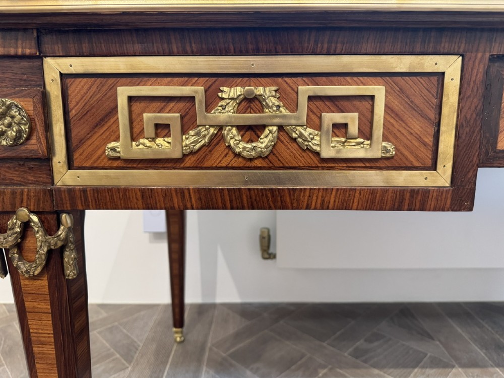 A French Louis XVI style writing desk featuring a green leather insert, wood parquetry veneer, three frieze drawers, and gilt bronze mounts. View XIII