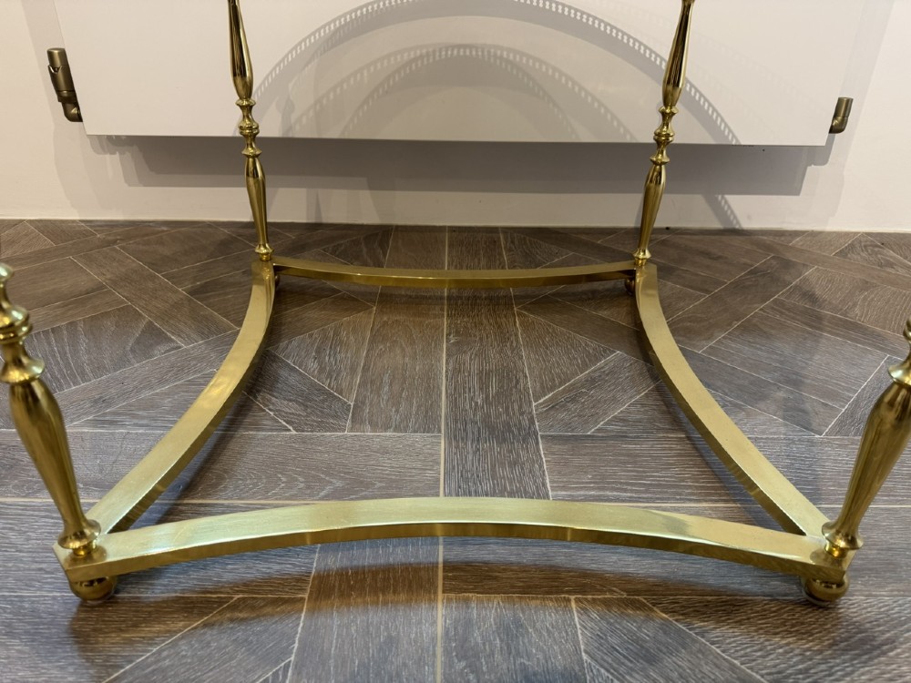 A circular brass coffee table featuring a dark smoked glass top, a pierced gallery rim, turned legs, and a curved stretcher base. View VI