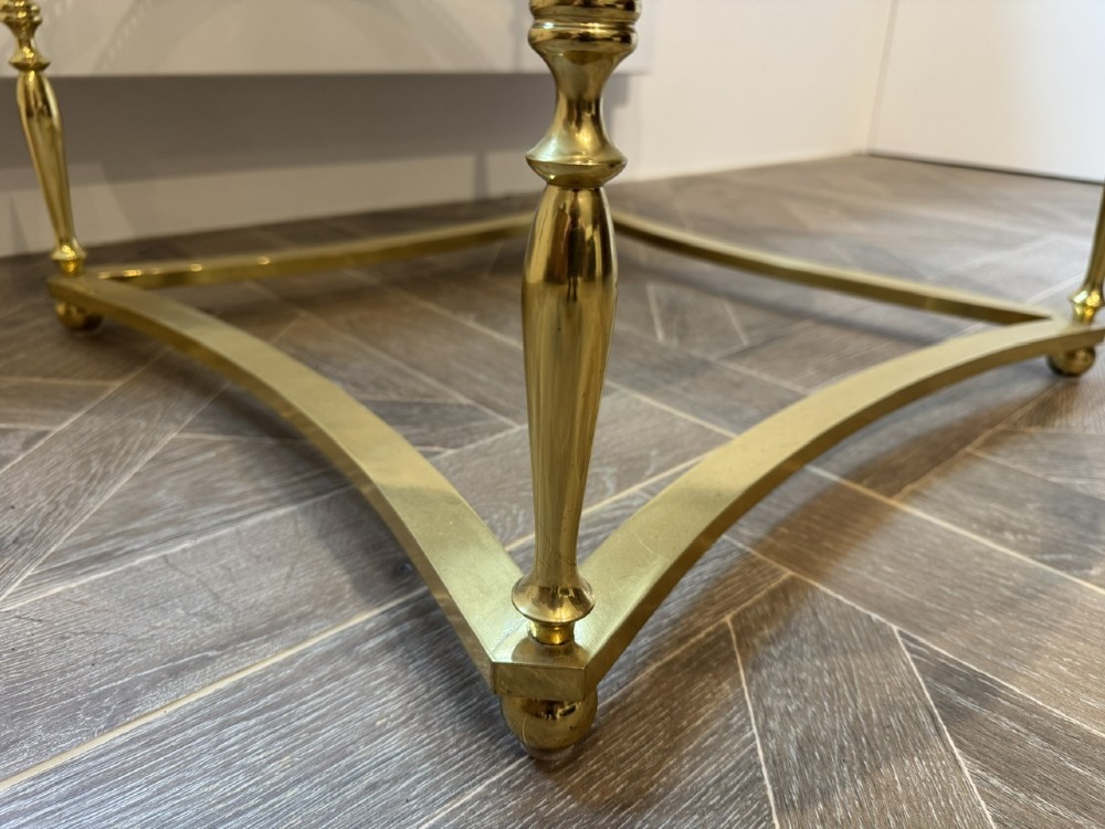 A circular brass coffee table featuring a dark smoked glass top, a pierced gallery rim, turned legs, and a curved stretcher base. View VIII