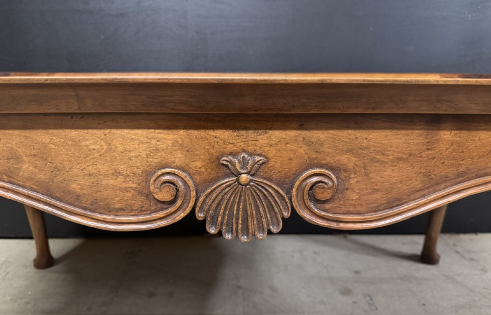 A burr walnut low coffee table featuring cabriole legs, a carved shell motif on the central apron, and a raised moulded edge around the top. View III