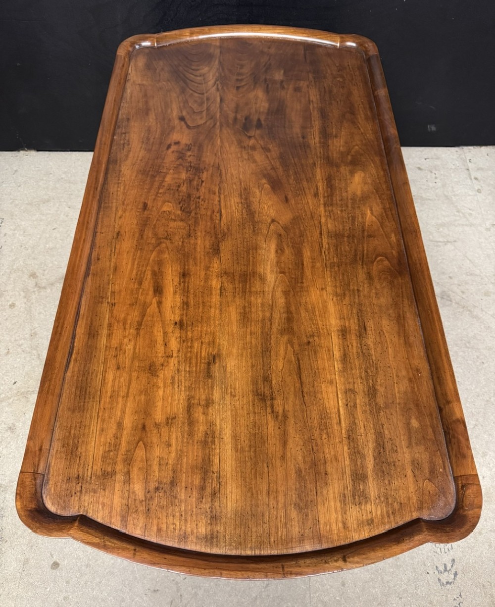 A burr walnut low coffee table featuring cabriole legs, a carved shell motif on the central apron, and a raised moulded edge around the top. View VI