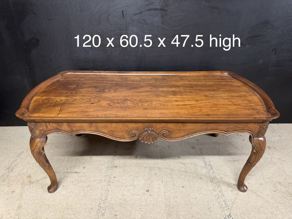 A burr walnut low coffee table featuring cabriole legs, a carved shell motif on the central apron, and a raised moulded edge around the top. View X