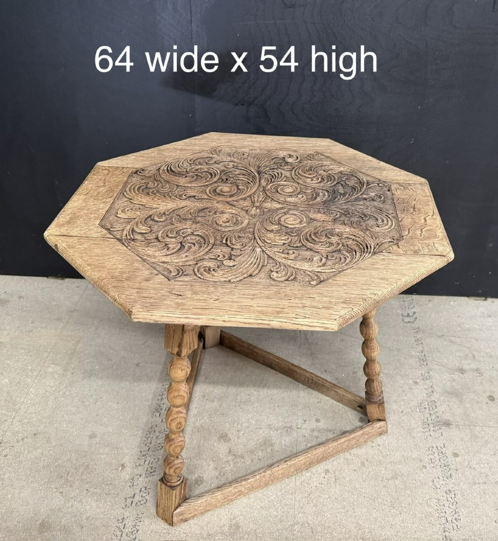 A hexagonal carved oak cricket table featuring elaborate foliate scrollwork on the tabletop and three turned legs joined by stretchers. View II