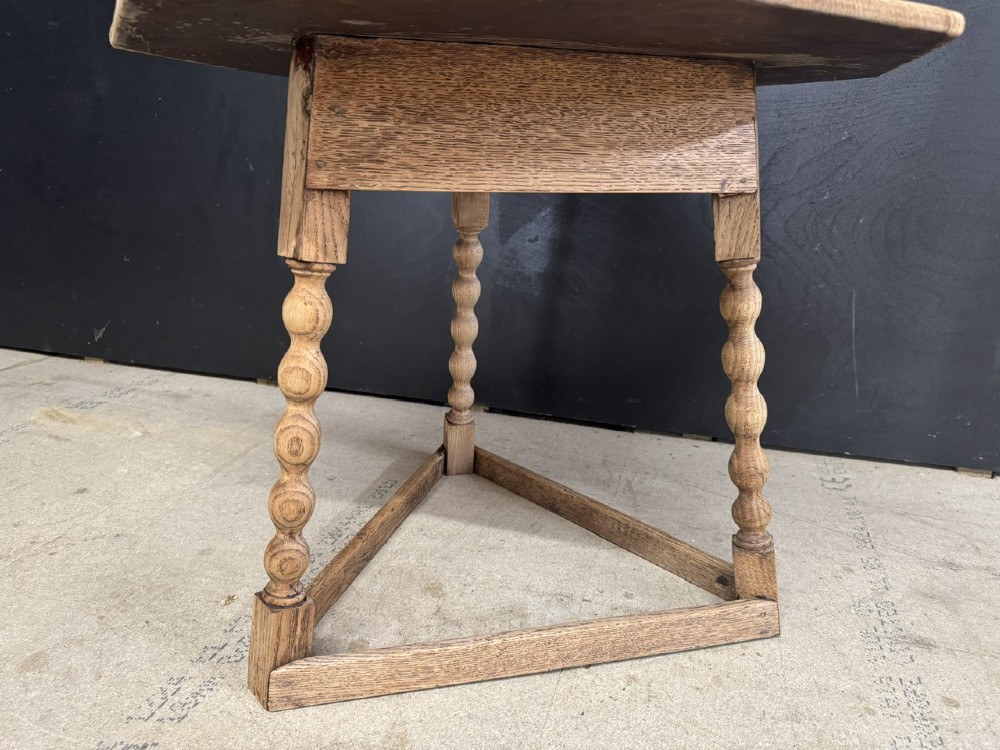 A hexagonal carved oak cricket table featuring elaborate foliate scrollwork on the tabletop and three turned legs joined by stretchers. View IV