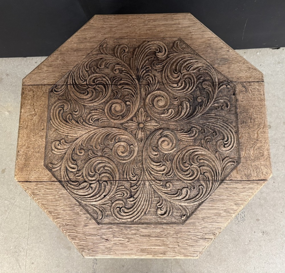 A hexagonal carved oak cricket table featuring elaborate foliate scrollwork on the tabletop and three turned legs joined by stretchers. View VI