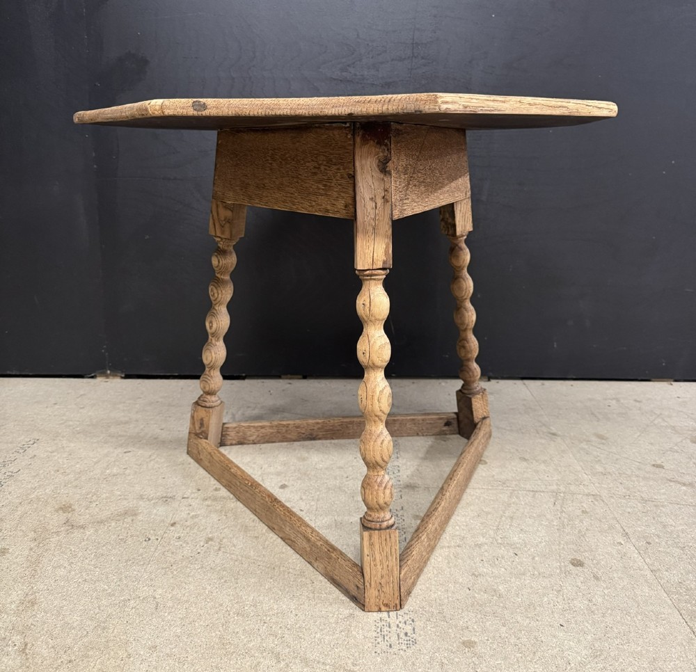 A hexagonal carved oak cricket table featuring elaborate foliate scrollwork on the tabletop and three turned legs joined by stretchers. View VIII