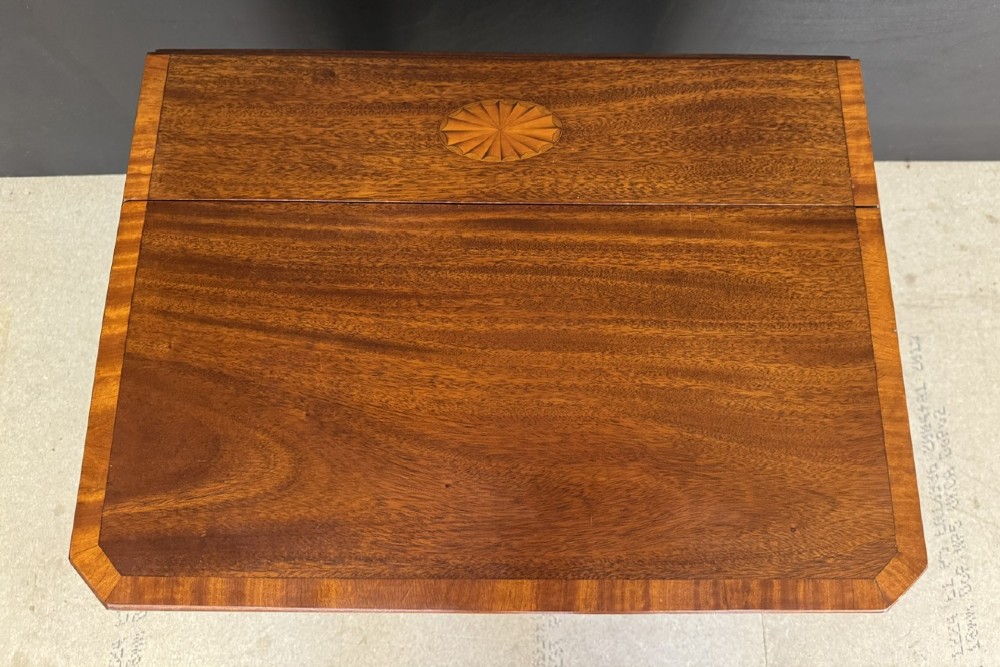 An Edwardian mahogany Sutherland table featuring drop leaves with satinwood crossbanding, central marquetry inlay, turned legs, and gateleg supports on castors. View IV
