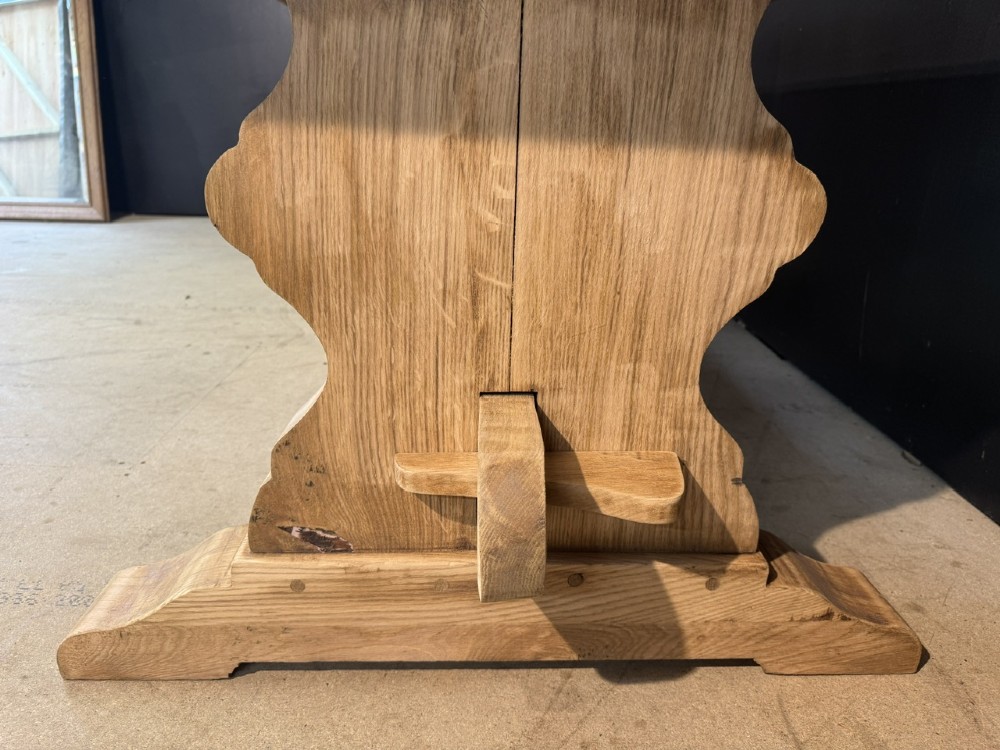 A large light oak farmhouse dining table featuring a solid plank top with breadboard ends supported by a shaped trestle base and a central stretcher rail. View IX
