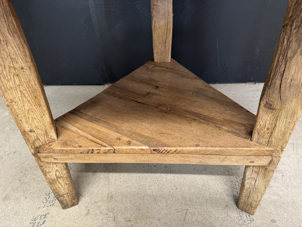 A rustic antique pine cricket table featuring a circular wooden top supported by three sturdy legs and a low triangular shelf. View V
