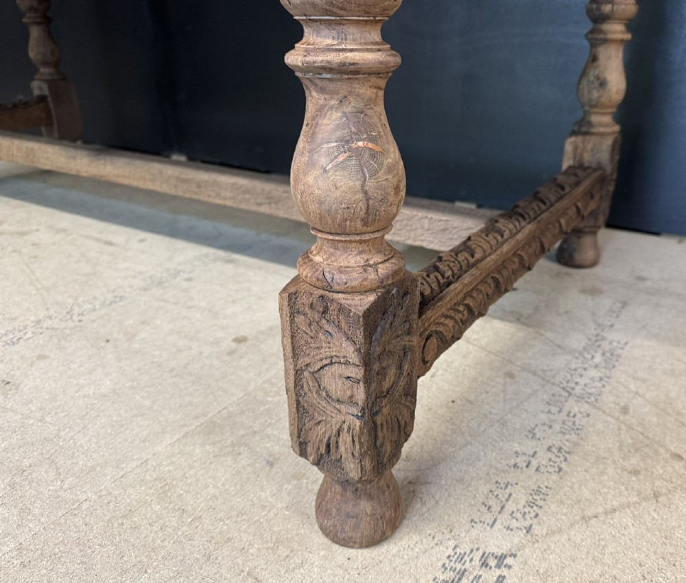 A light oak table featuring a detailed relief-carved frieze with human figures and a profile medallion, supported by turned legs and a central stretcher. View IX