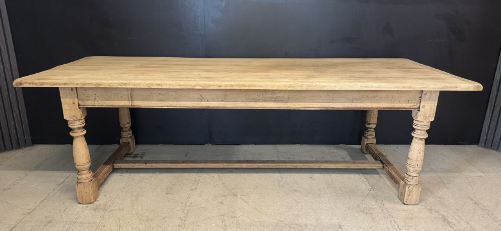 Large rectangular light oak farmhouse dining table featuring turned legs and an H-stretcher base. View II