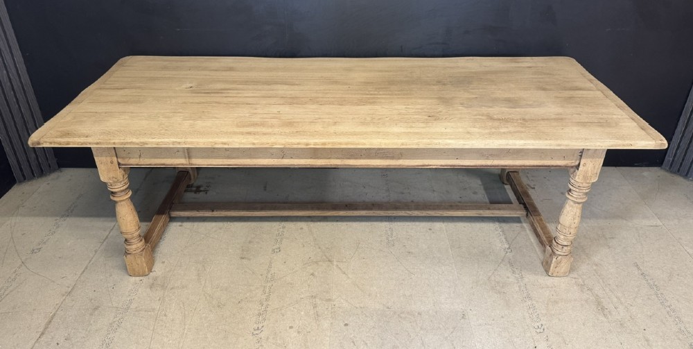 Large rectangular light oak farmhouse dining table featuring turned legs and an H-stretcher base. View III