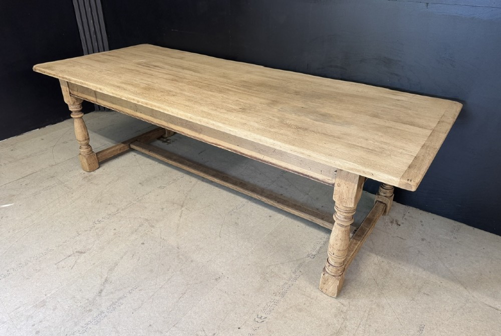 Large rectangular light oak farmhouse dining table featuring turned legs and an H-stretcher base. View IV