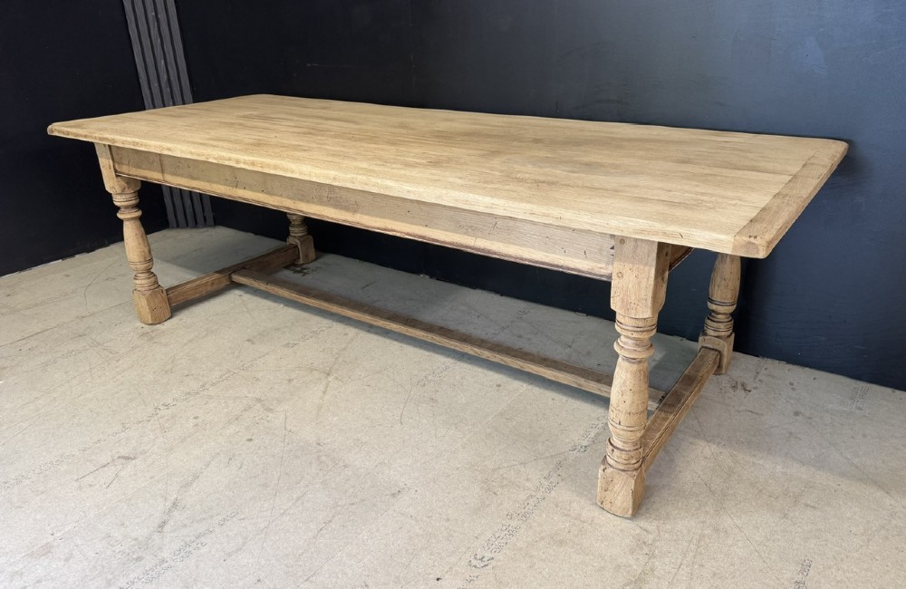 Large rectangular light oak farmhouse dining table featuring turned legs and an H-stretcher base. View V