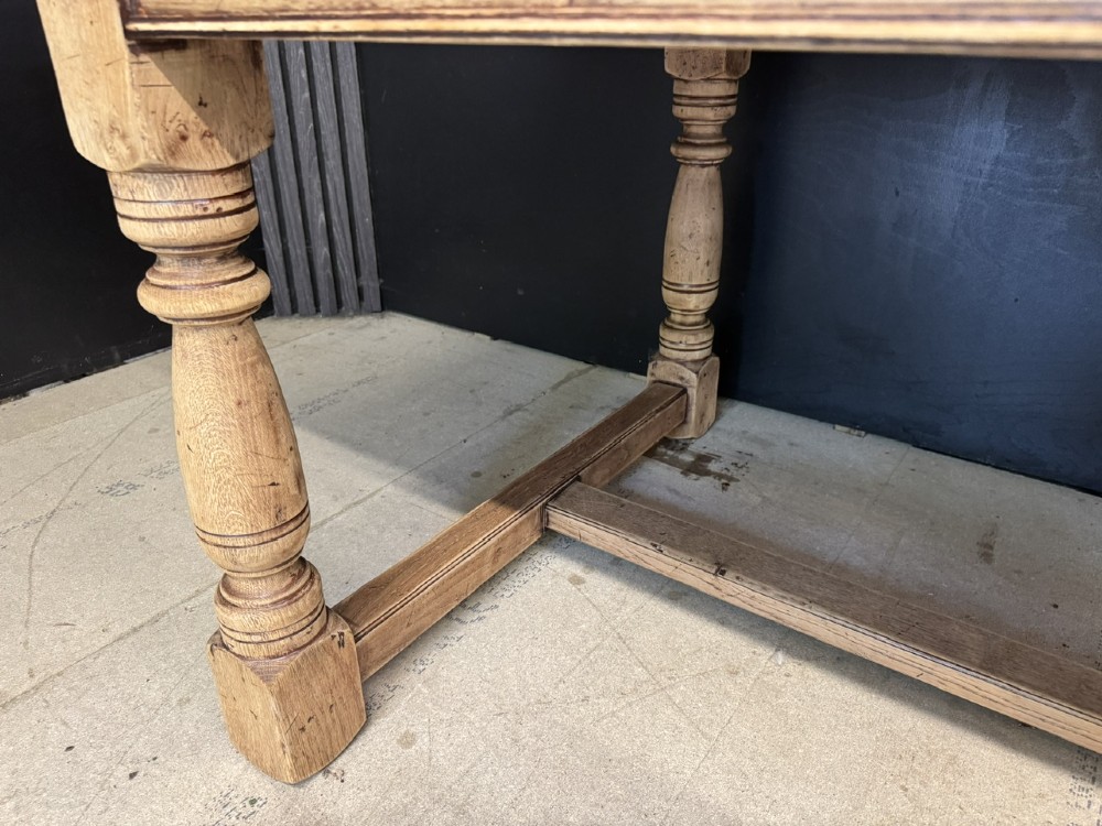 Large rectangular light oak farmhouse dining table featuring turned legs and an H-stretcher base. View XI