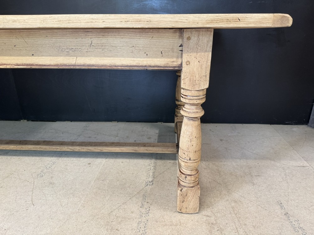 Large rectangular light oak farmhouse dining table featuring turned legs and an H-stretcher base. View XIV