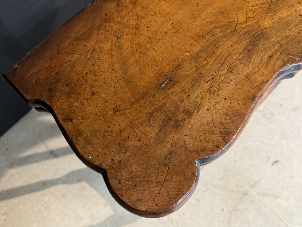 An antique walnut fold-over tea table with a shaped double top, contoured frieze, turned legs, and a lower box stretcher. View IX