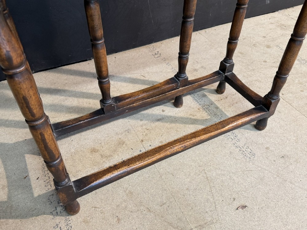 An antique walnut fold-over tea table with a shaped double top, contoured frieze, turned legs, and a lower box stretcher. View X