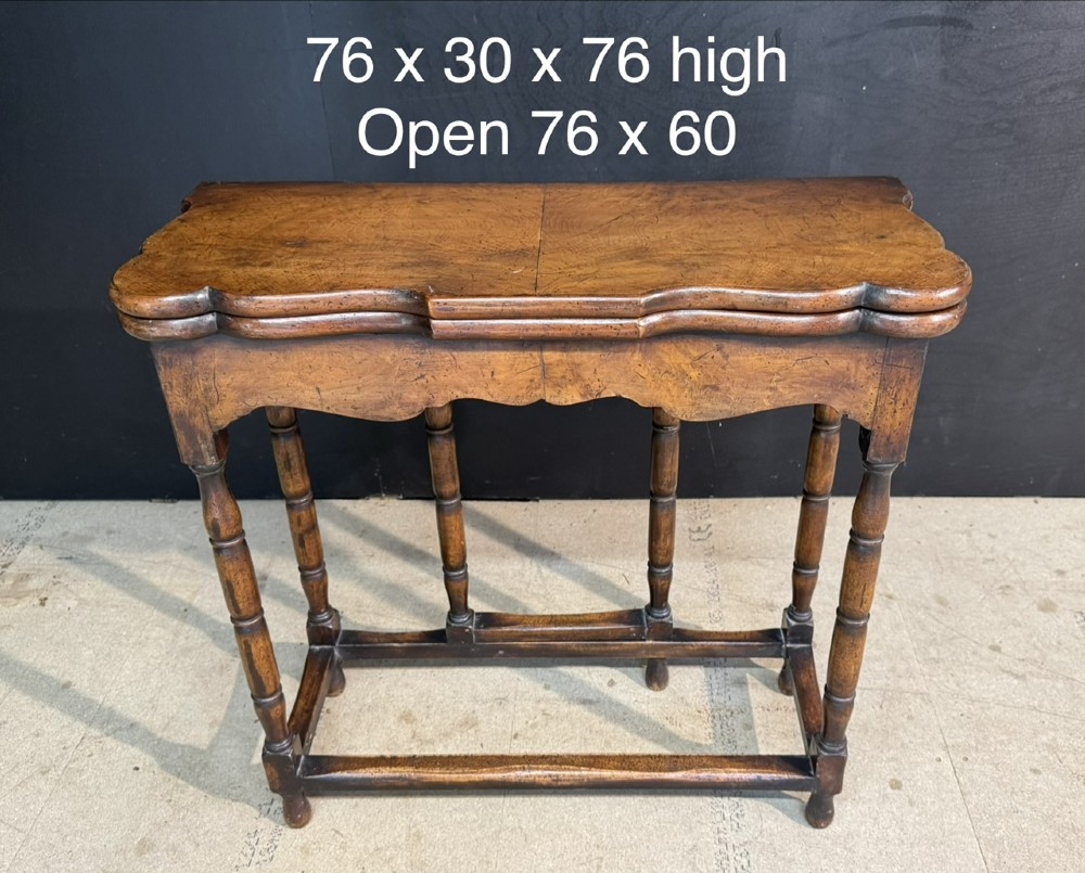 An antique walnut fold-over tea table with a shaped double top, contoured frieze, turned legs, and a lower box stretcher. View XII