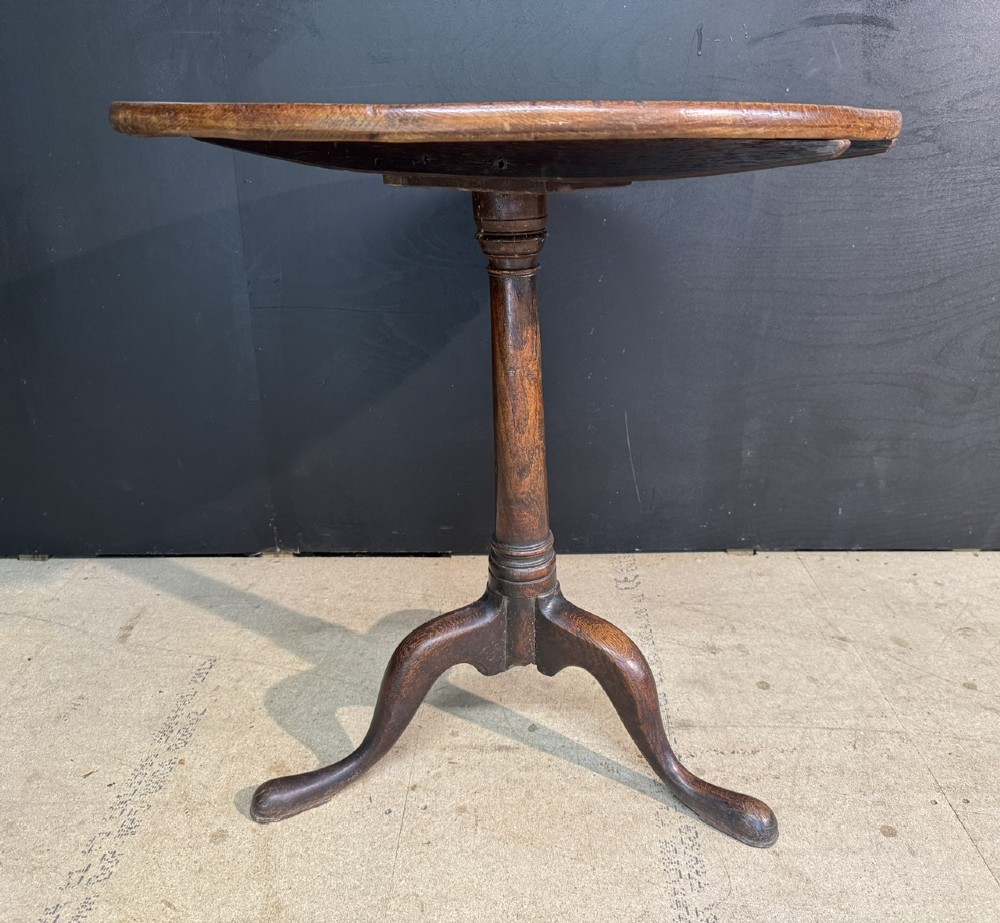 A Georgian solid oak tilt-top table with a circular surface supported by a turned pedestal column and three cabriole tripod legs. View II