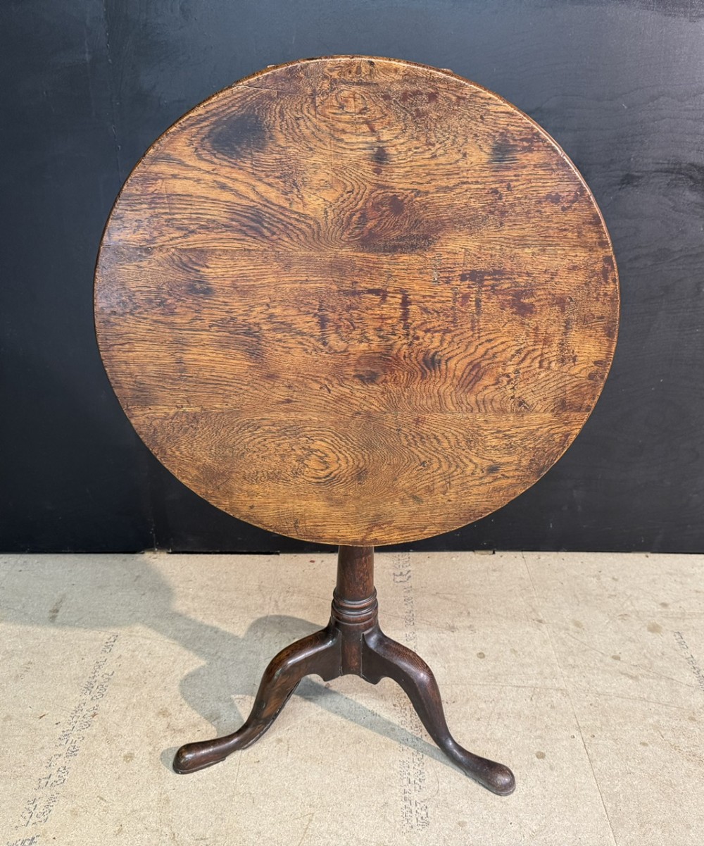 A Georgian solid oak tilt-top table with a circular surface supported by a turned pedestal column and three cabriole tripod legs. View IV