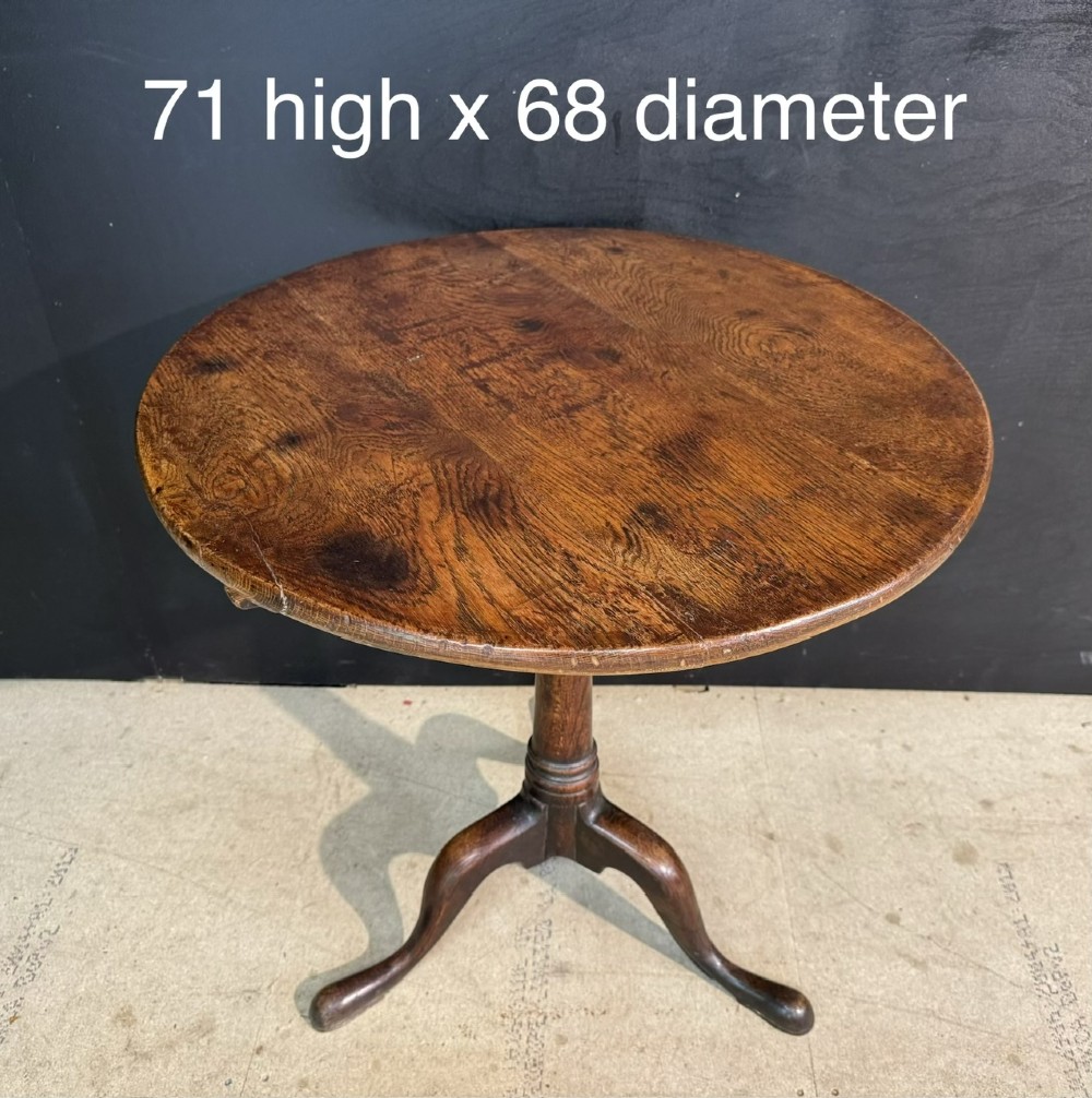 A Georgian solid oak tilt-top table with a circular surface supported by a turned pedestal column and three cabriole tripod legs. View IX