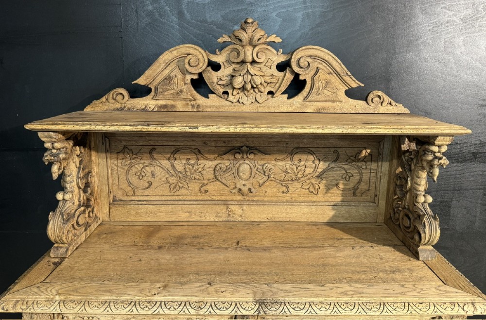 A 19th-century French carved oak buffet featuring an ornate crest, open shelf, turned columns, and carved drawers. View III