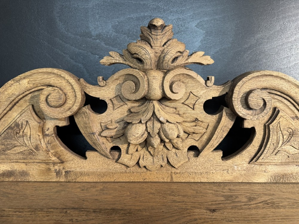 A 19th-century French carved oak buffet featuring an ornate crest, open shelf, turned columns, and carved drawers. View IV